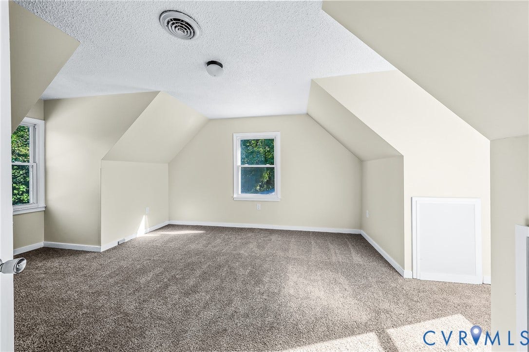 Sloped ceilings, two windows, textured ceiling, wall-to-wall carpeting, and a built-in access panel