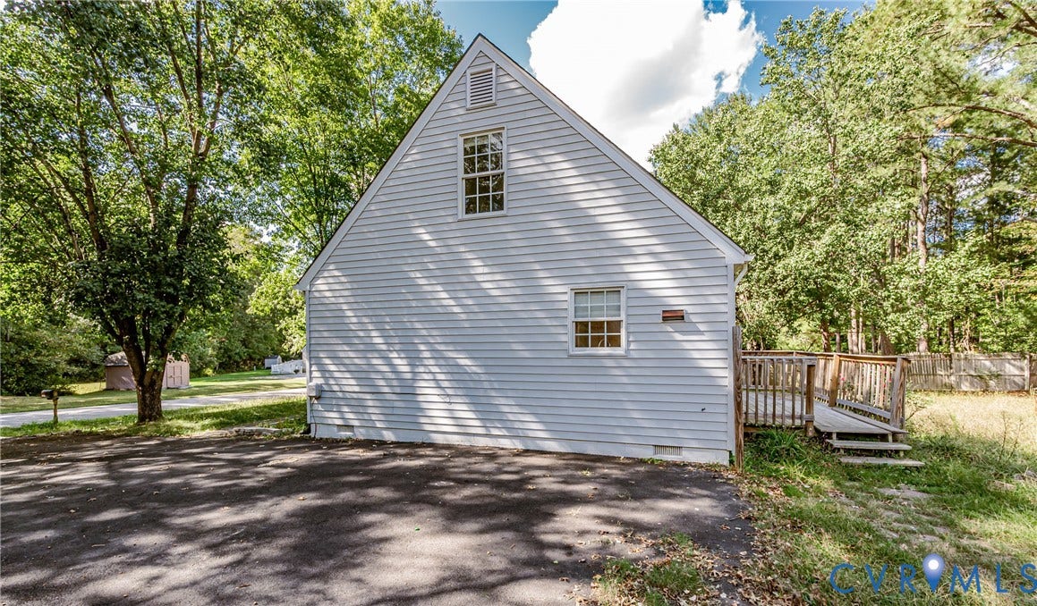 Gable-roofed residence with horizontal siding, multiple windows, and an exterior wood deck