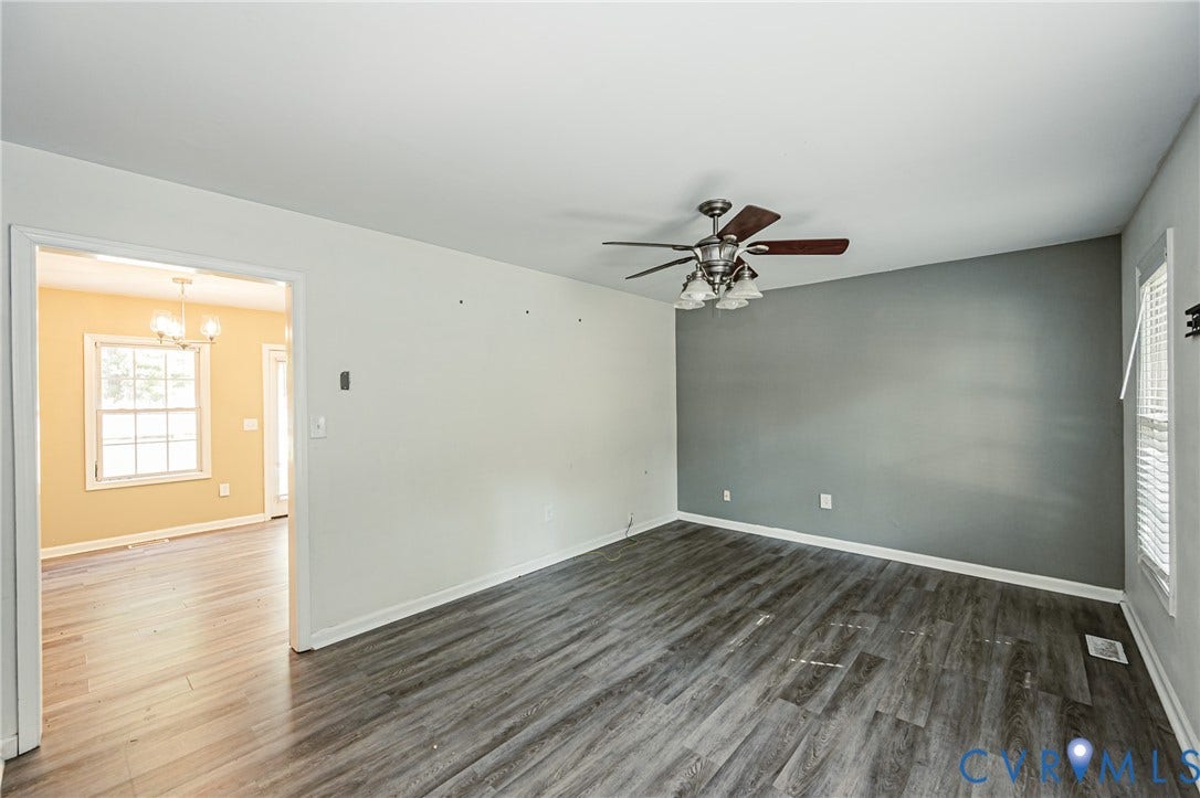 Wood-finish flooring, ceiling fan with light fixture, and a window with blinds