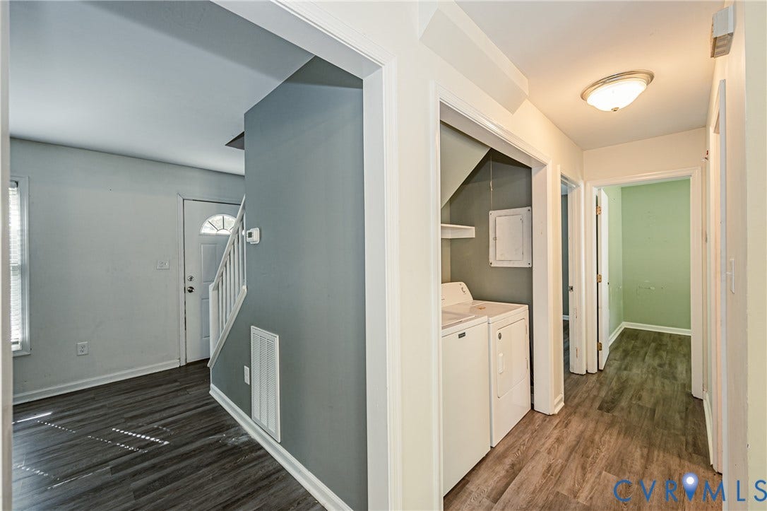 Wood-finish flooring throughout, white interior doors, and a dedicated laundry area with stacked appliances