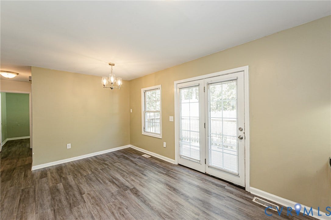 Wood-finish flooring throughout, with a brass-finish chandelier and white trim
