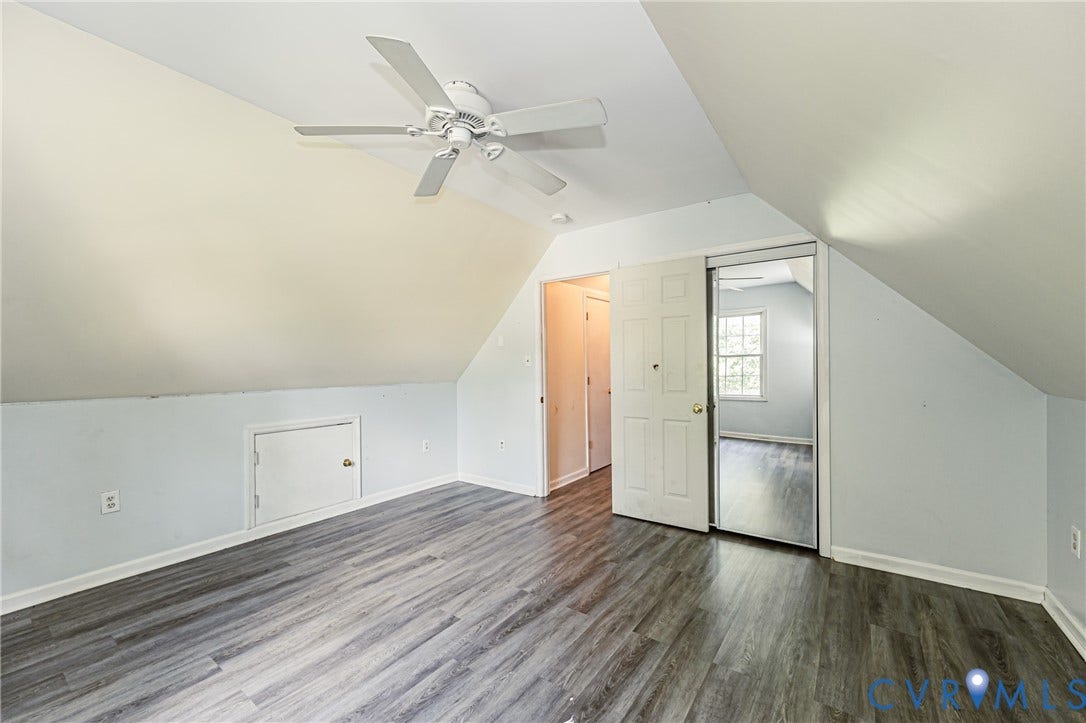 Sloped ceilings, wood-finish flooring, ceiling fan, and built-in storage access