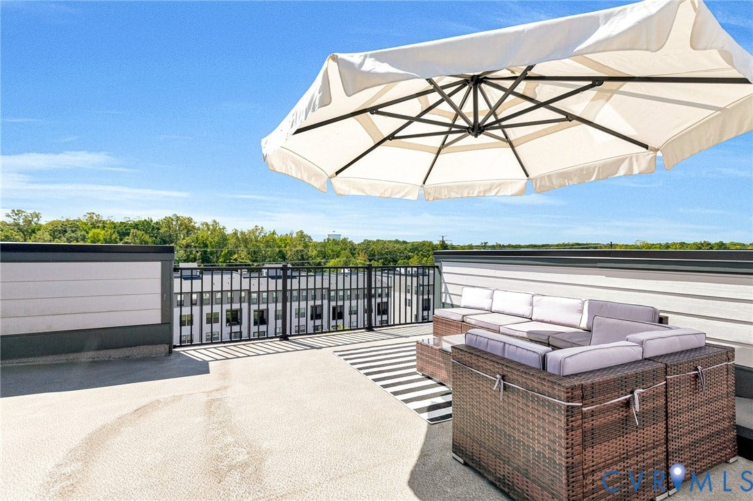 Rooftop deck featuring a metal railing, composite siding, and an expansive concrete surface