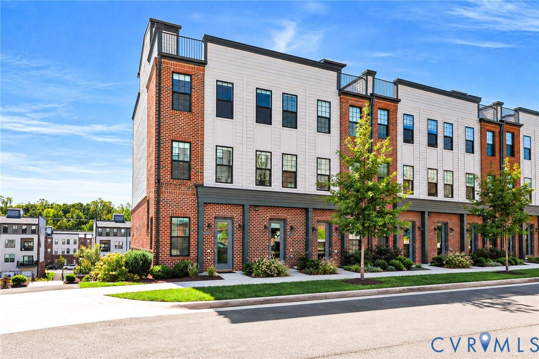 Brick and siding exterior featuring multiple windows and a rooftop terrace