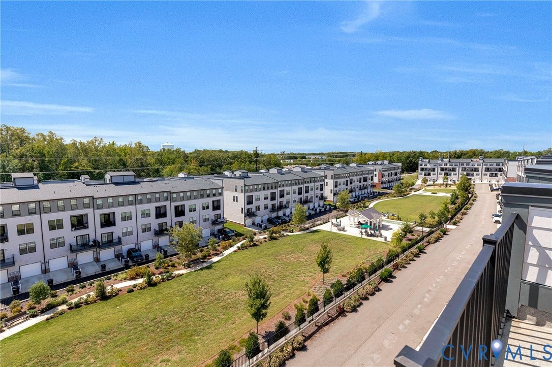 Modern townhome community featuring multi-level residences, an expansive green space, and a community gazebo