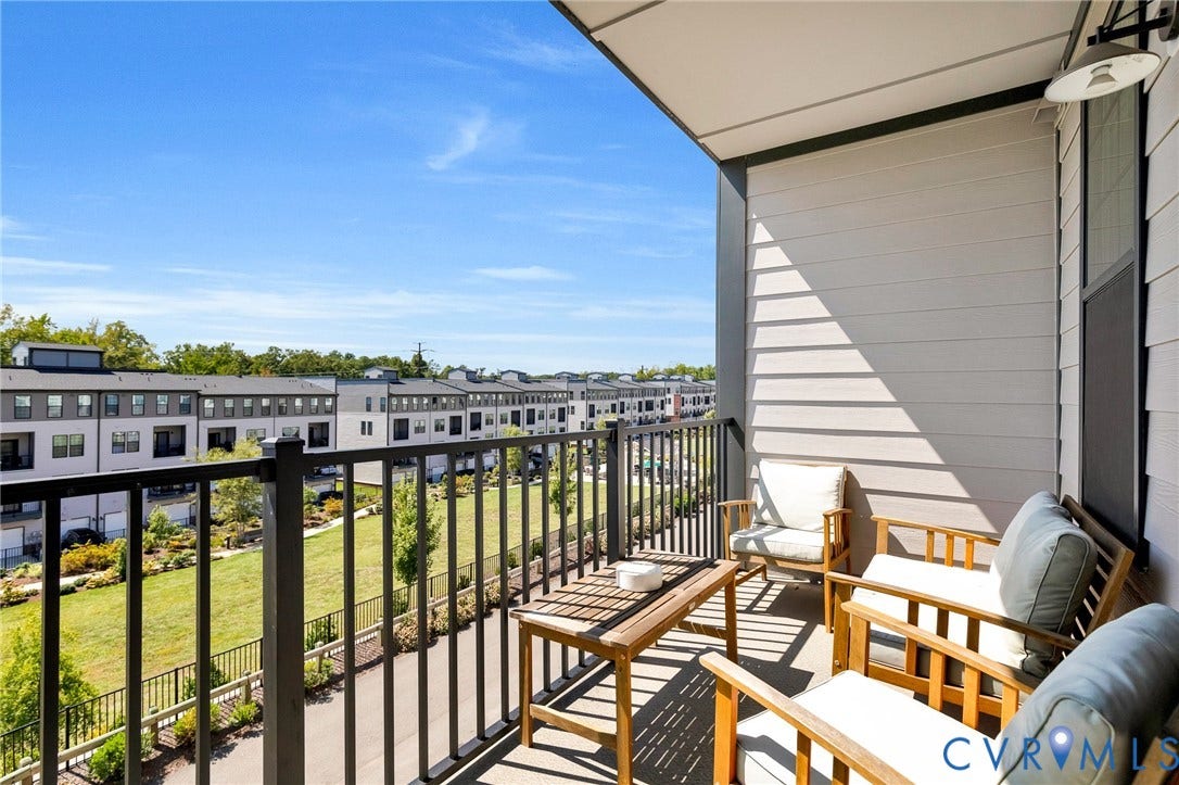 Private balcony with a metal railing and a concrete floor