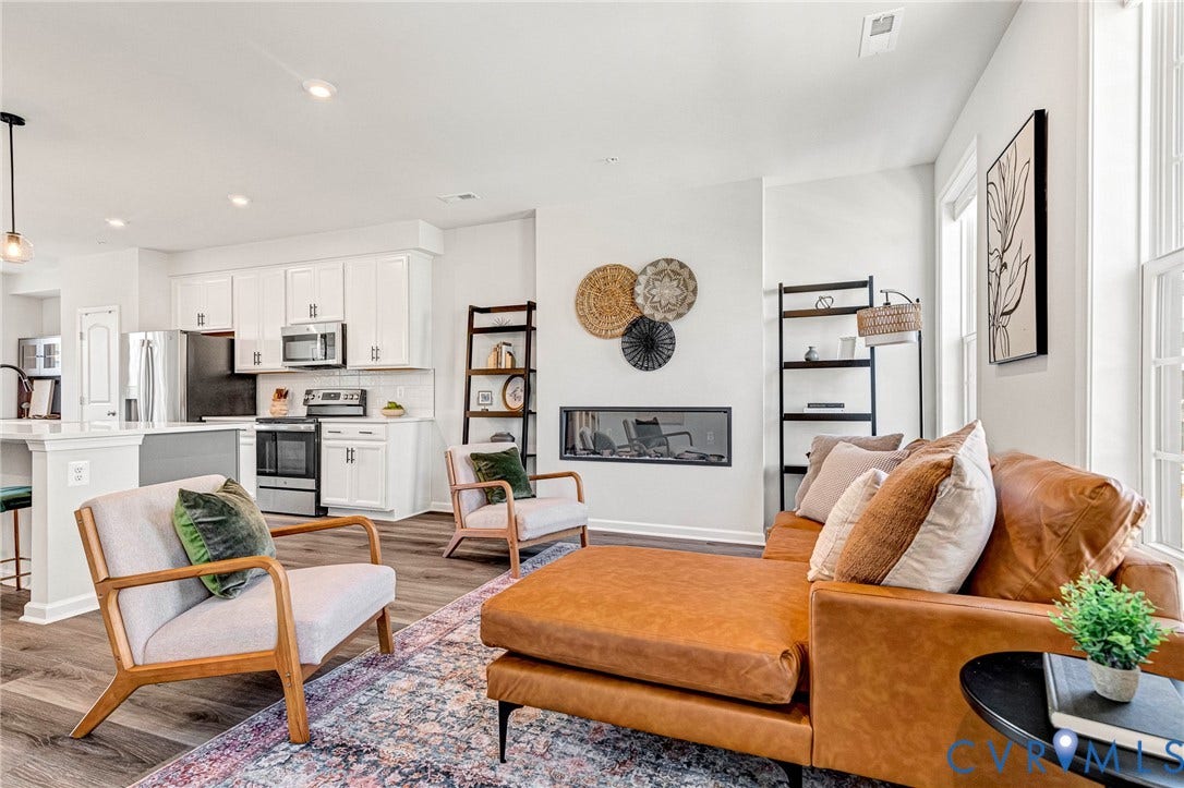 Open-concept living area featuring wood-finish flooring, a linear electric fireplace, and recessed lighting