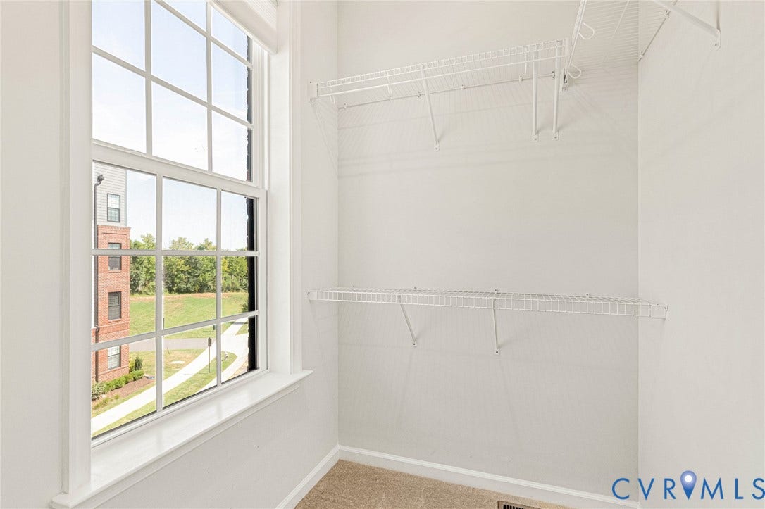 Tall window with grid panes, white trim, and a window sill
