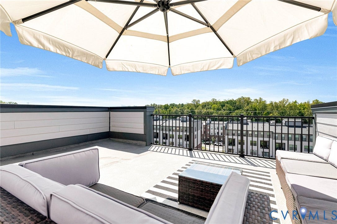Rooftop terrace with a light-colored parasol and dark metal railing