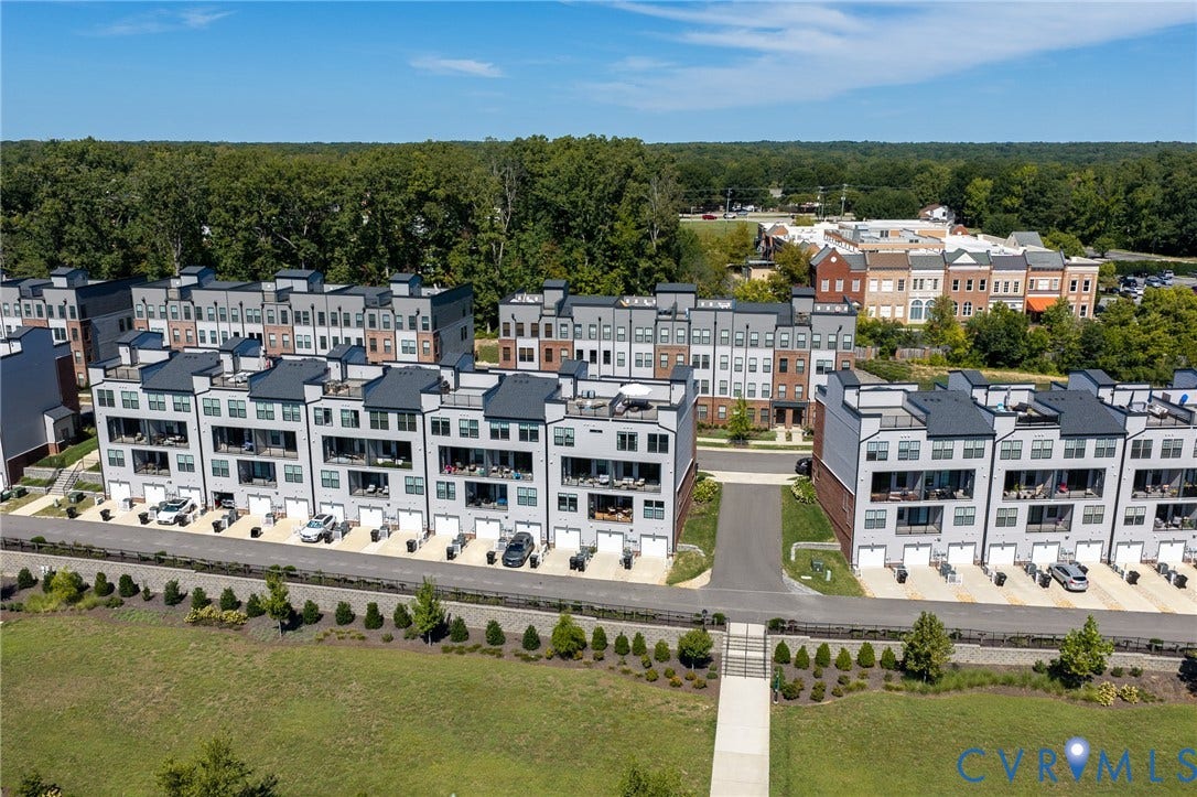 Contemporary townhome community with integrated garages, private balconies, and flat roofs