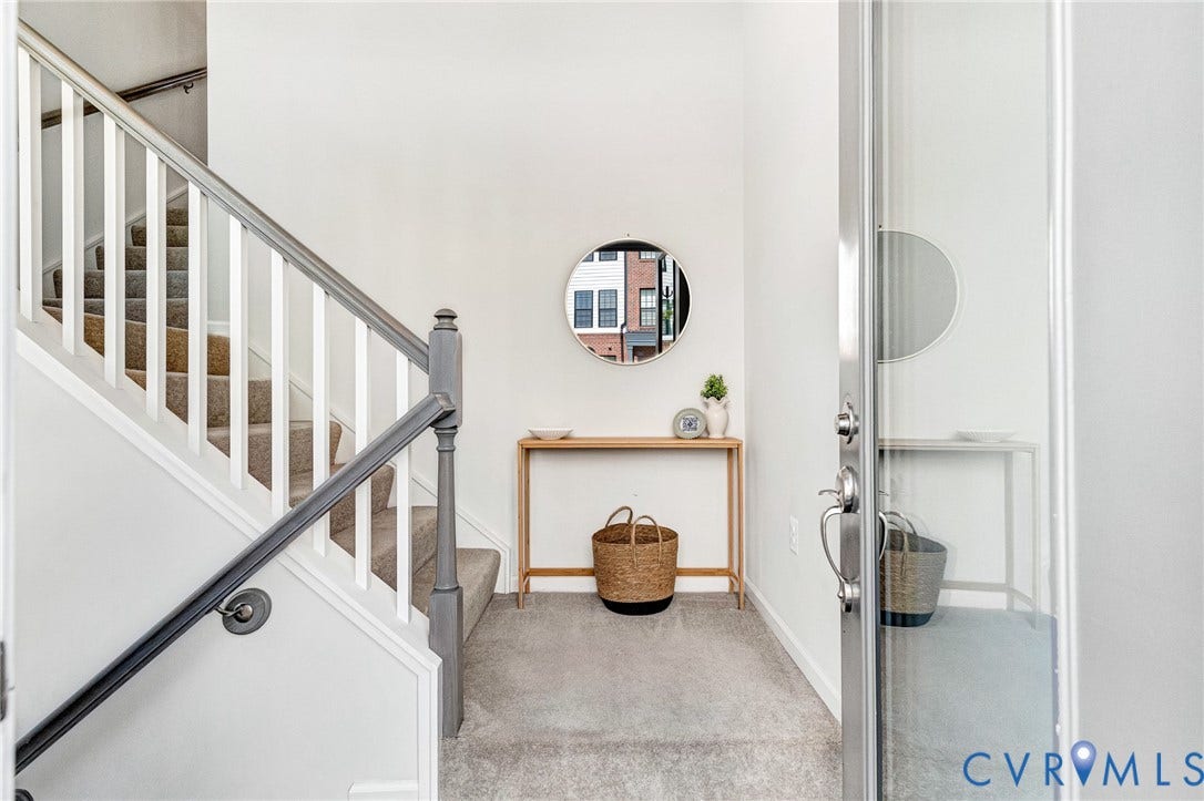 Staircase with carpeted treads and a painted handrail