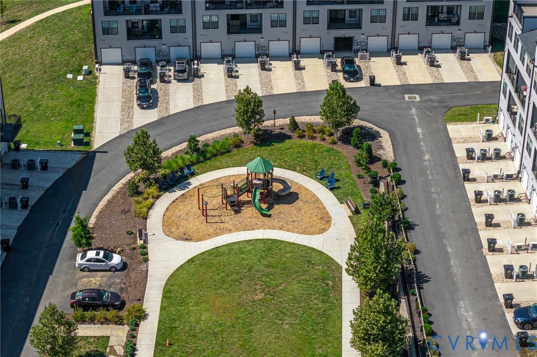 Central green space featuring a playground, manicured lawn, and paved walkways