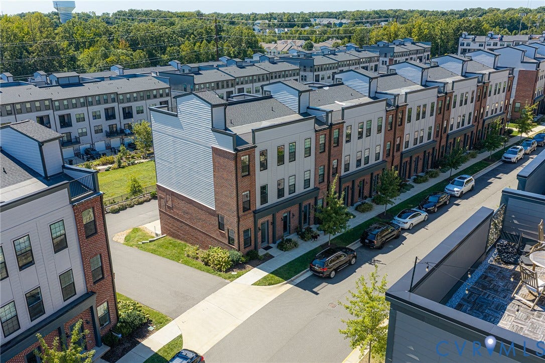 Contemporary townhome architecture featuring brick and siding exteriors, multiple levels, and individual entrances