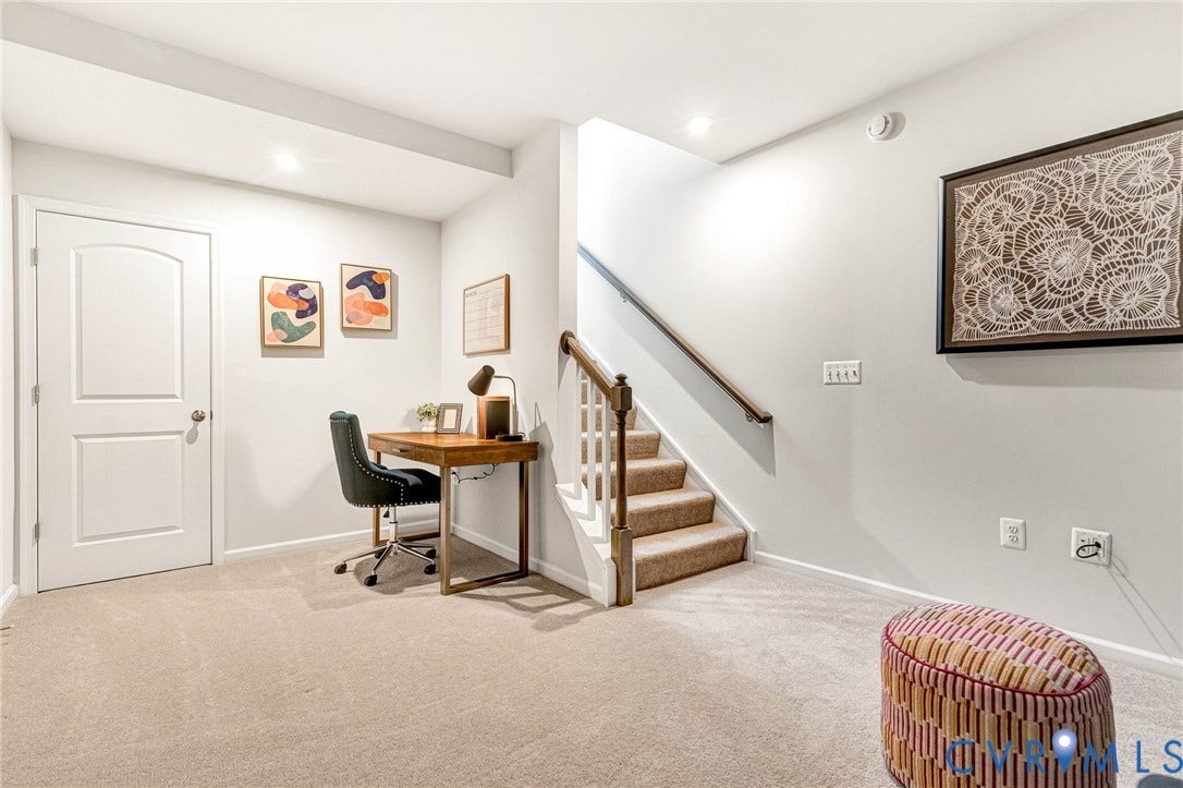 Carpeted flooring, recessed lighting, white interior door, light-toned wall paint, and a staircase with a wooden handrail