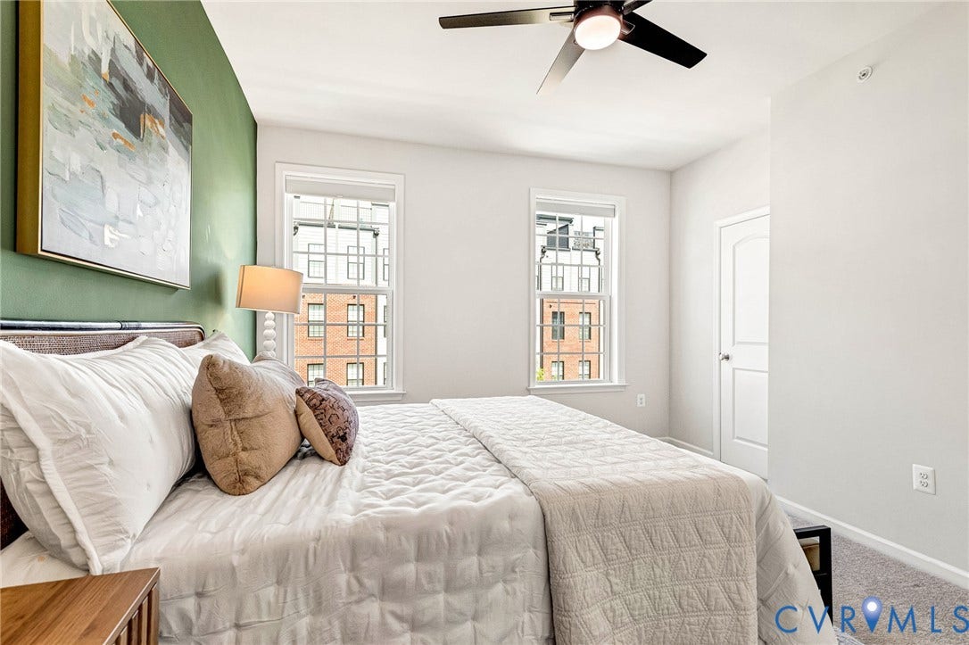 Dual windows, ceiling fan with integrated lighting, carpeted flooring, and a solid-panel interior door