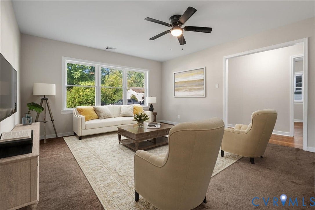 Expansive windows, ceiling fan, carpet flooring, recessed entryway, and a built-in media console