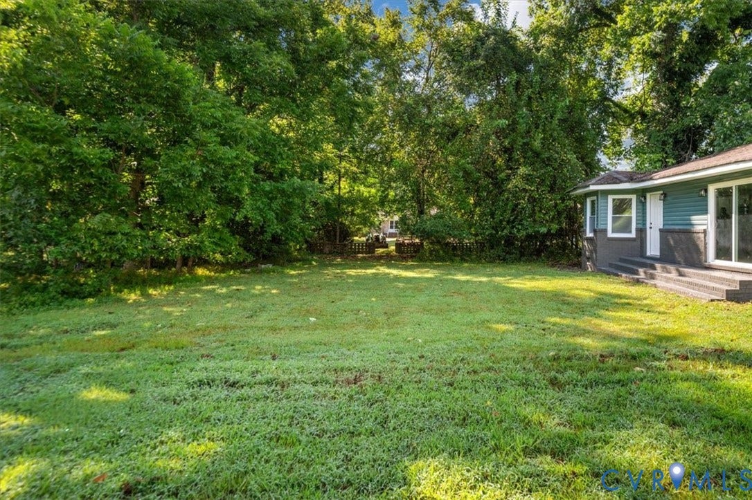 Expansive green lawn with mature perimeter trees, providing natural screening