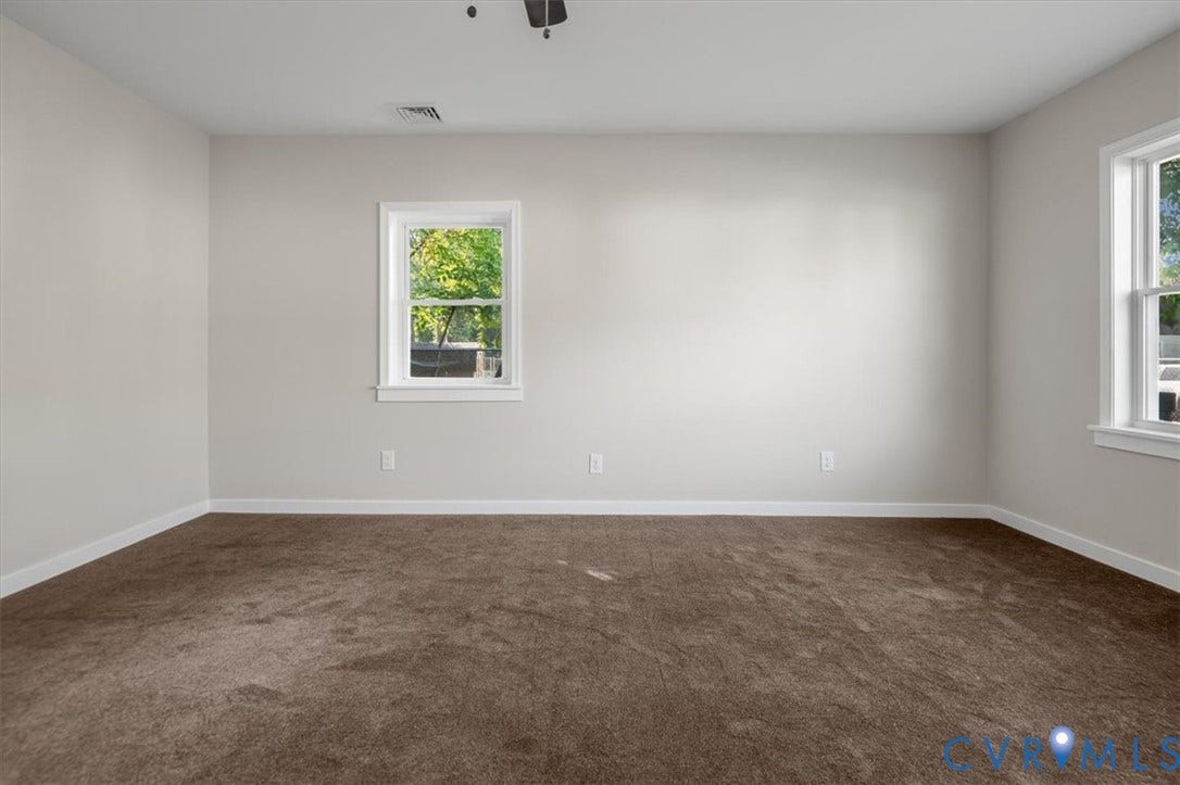 Neutral wall tones complement brown carpeting