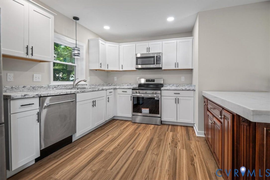 Kitchen featuring white cabinetry, stainless steel appliances, wood-finish flooring, light-toned countertops, and recessed lighting
