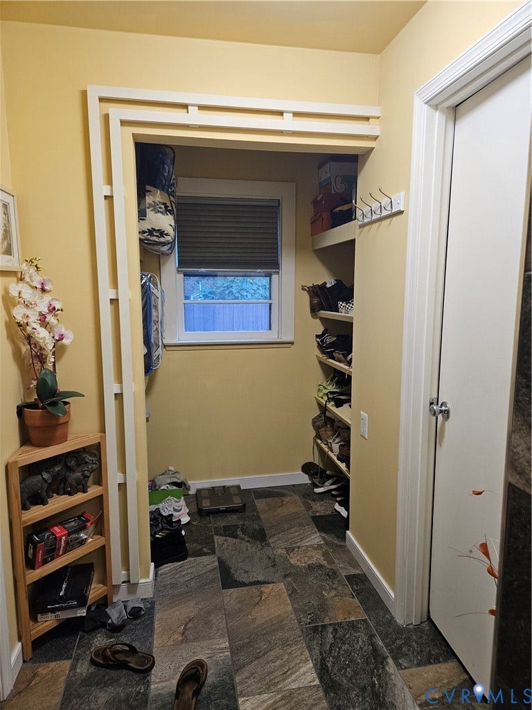 Built-in shelving, window with privacy blind, multi-tone tile flooring, and a white interior door