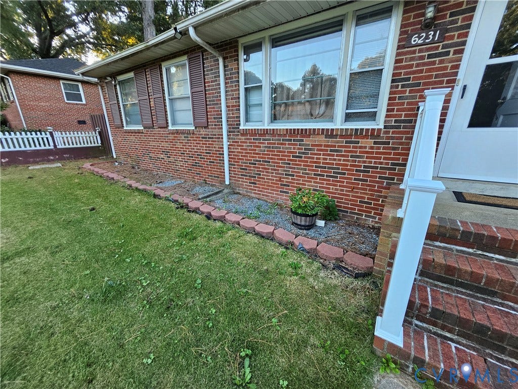 Brick exterior with white window frames and brown shutters