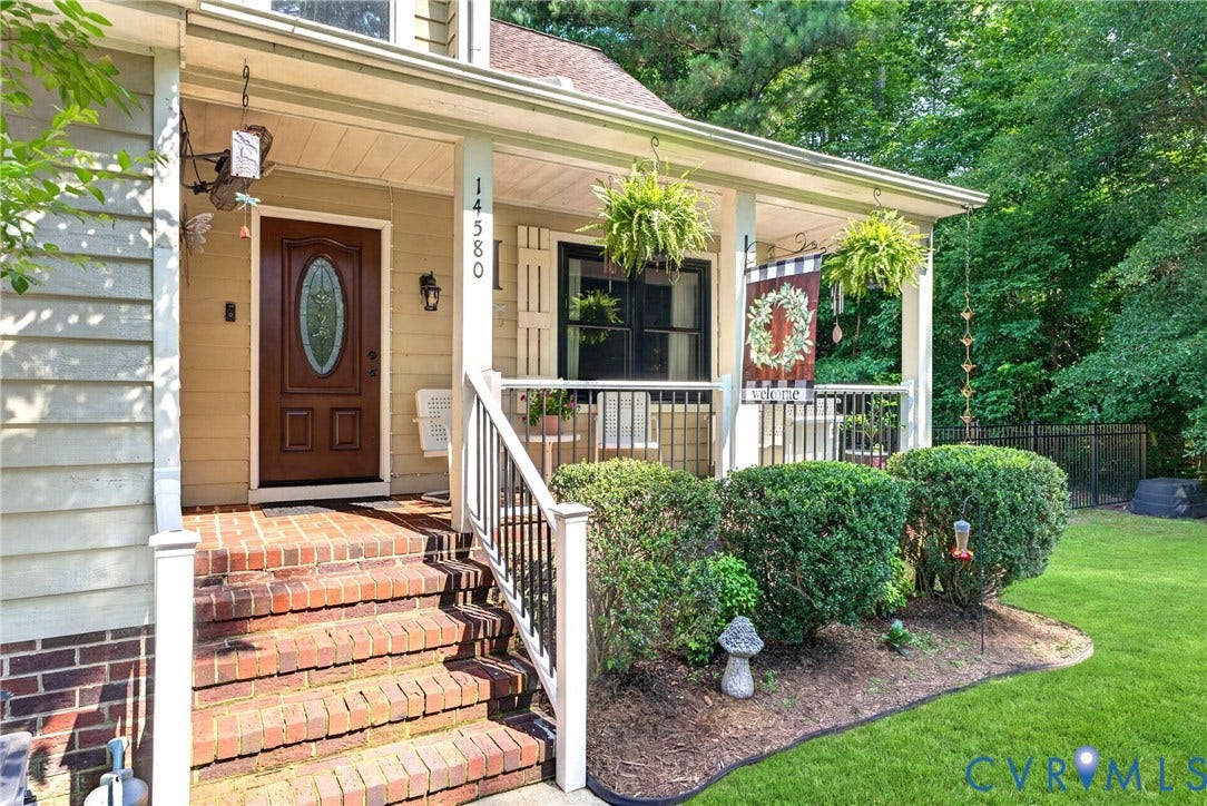 Inviting front porch featuring an entry door with an oval leaded glass inset and new Railings installed in May 2026