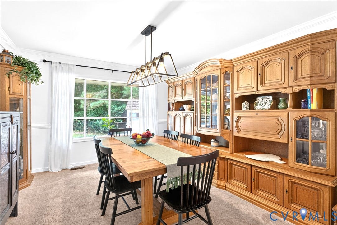 Spacious dining room featuring a Bay Window, Crown Molding, a modern Chandelier