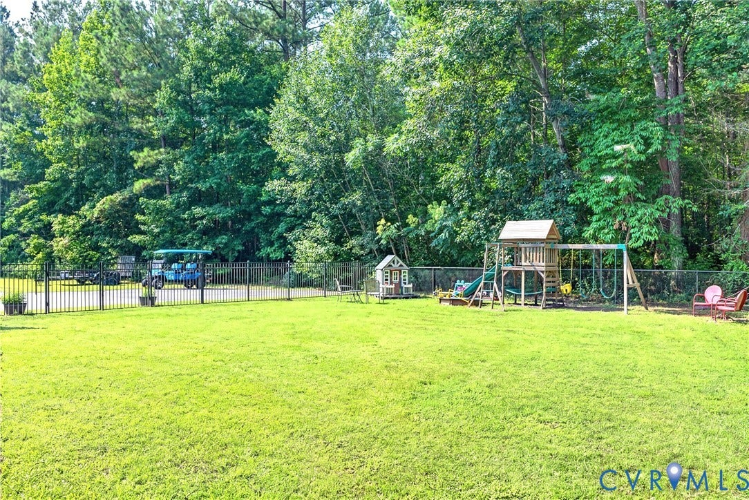 View 2 -  Lawn area with mature tree perimeter and black wrought iron fencing