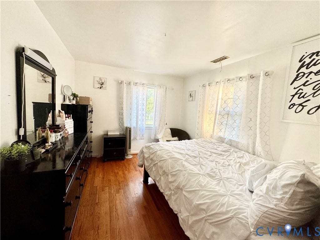 Wood-finish flooring with white walls and natural light from multiple windows