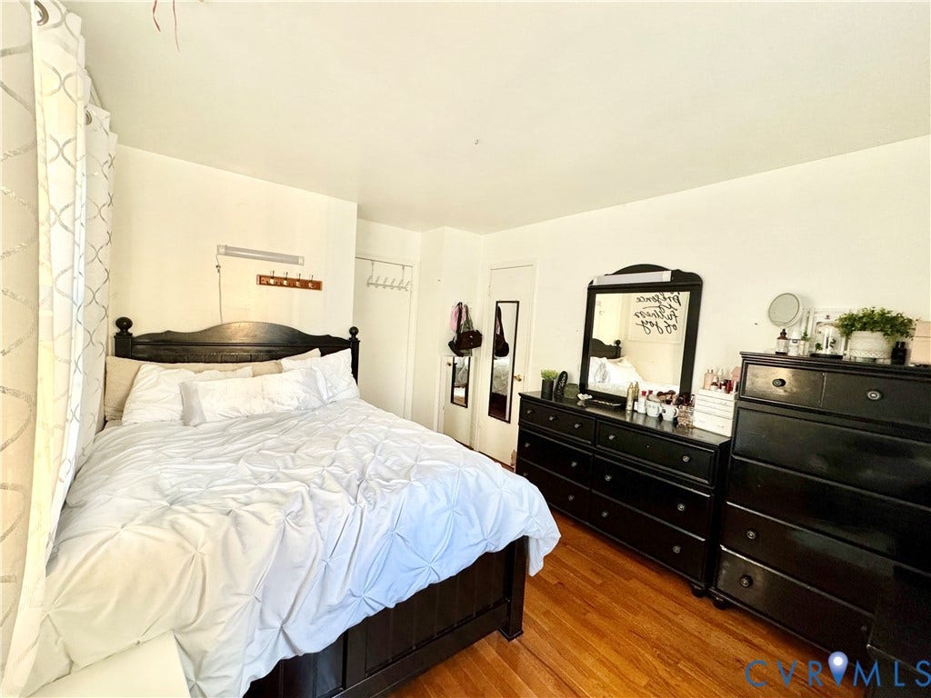 Hardwood-finish flooring, white painted walls, and a built-in wall hook rack