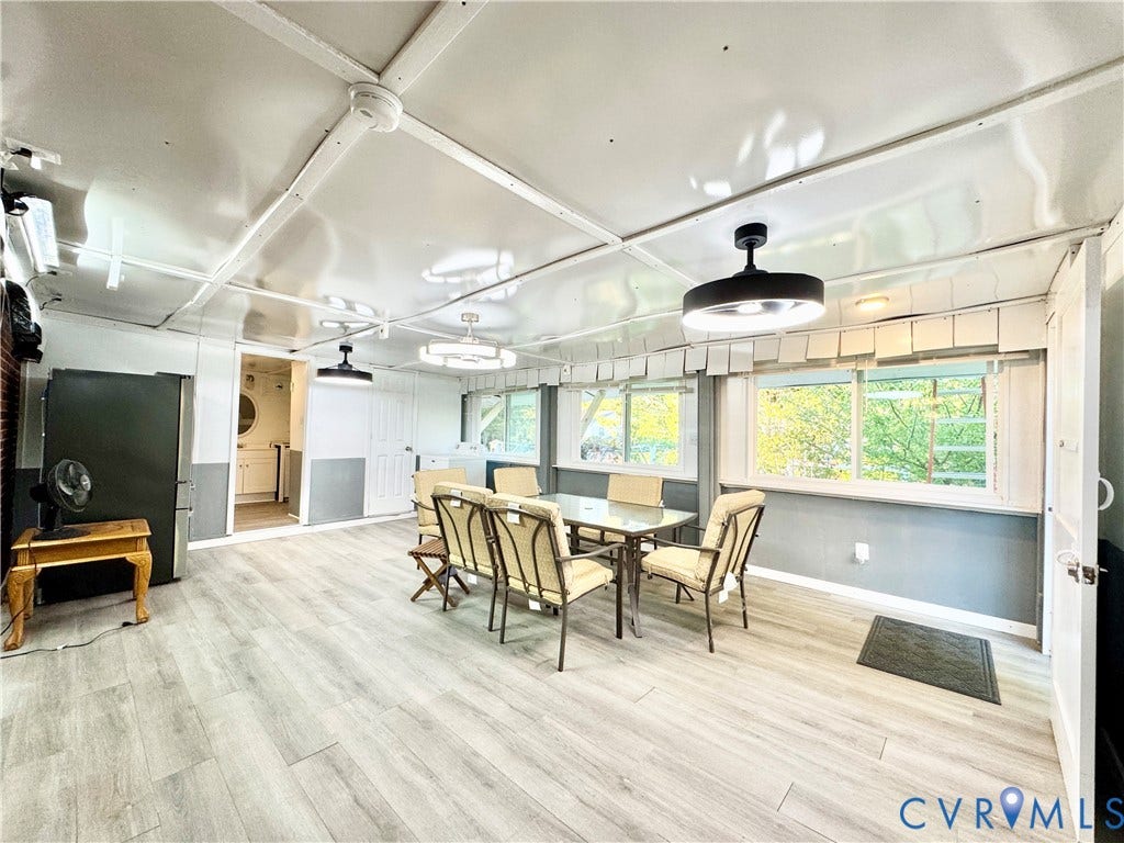 Wood-finish flooring, multiple windows, recessed lighting, and a neutral color palette