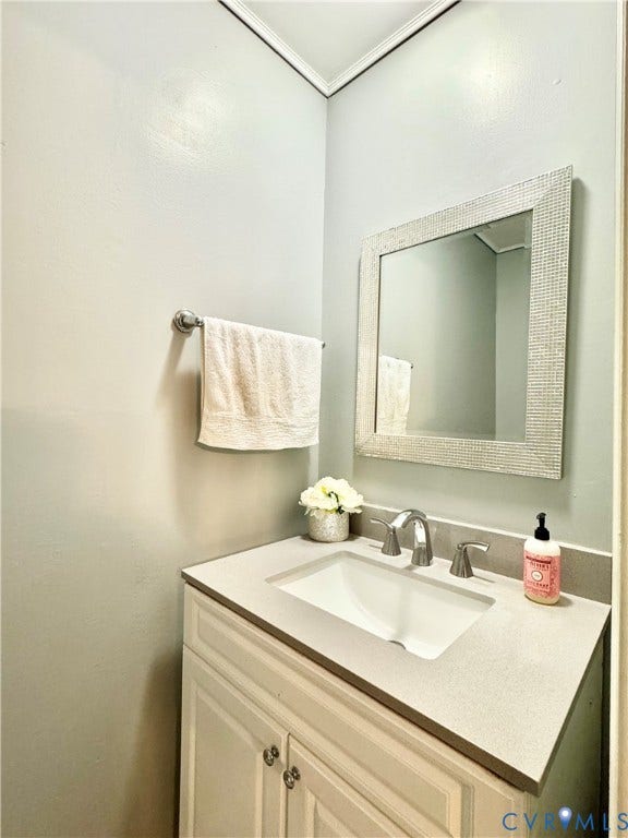 Vanity with an integrated sink, brushed nickel faucet, and light-colored countertop