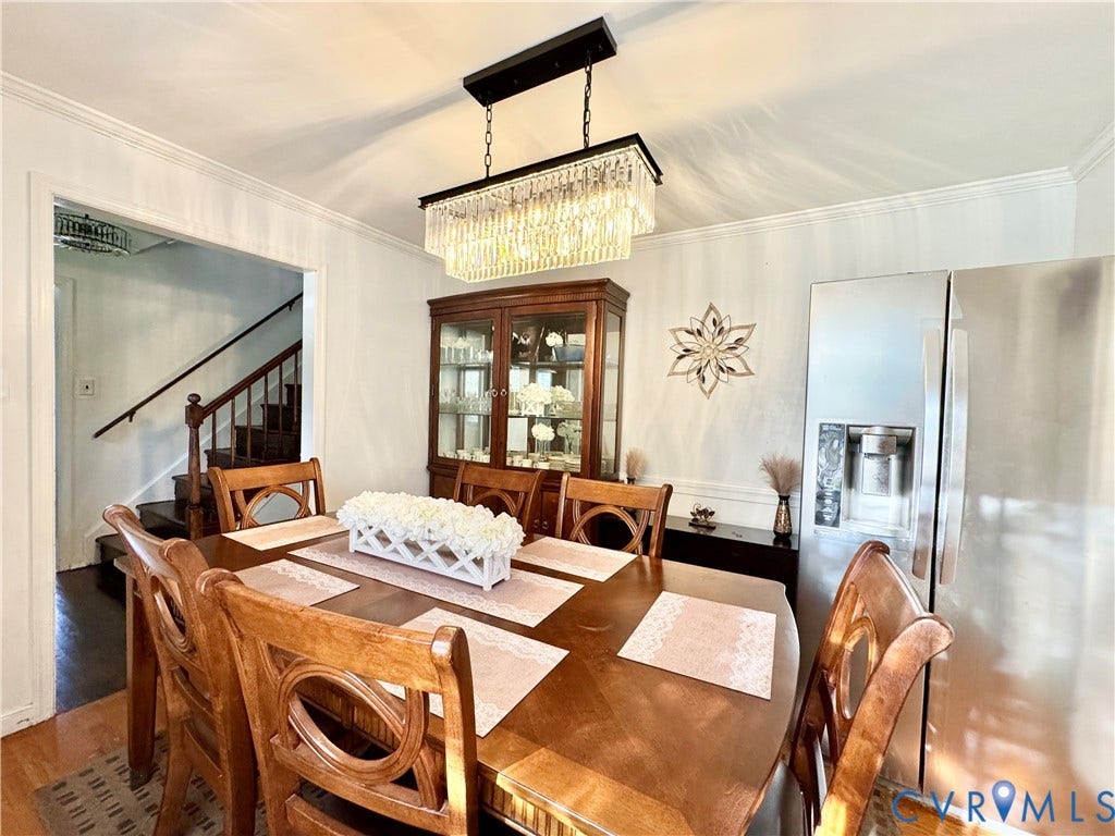 Dining area featuring a rectangular chandelier, built-in display cabinet, and crown molding
