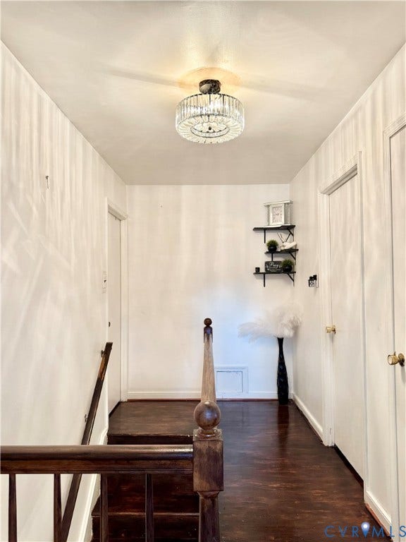 Dark wood-finish flooring, white walls, and a crystal semi-flush mount light fixture