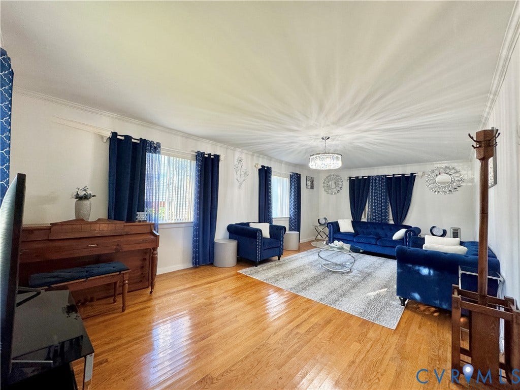 Hardwood flooring throughout, white crown molding, recessed lighting, and a contemporary chandelier