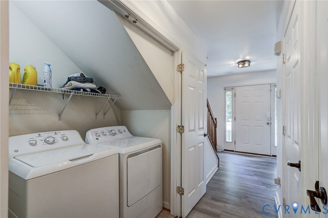 Entry foyer featuring wood-finish flooring, white paneled doors, and a built-in laundry area with wire shelving