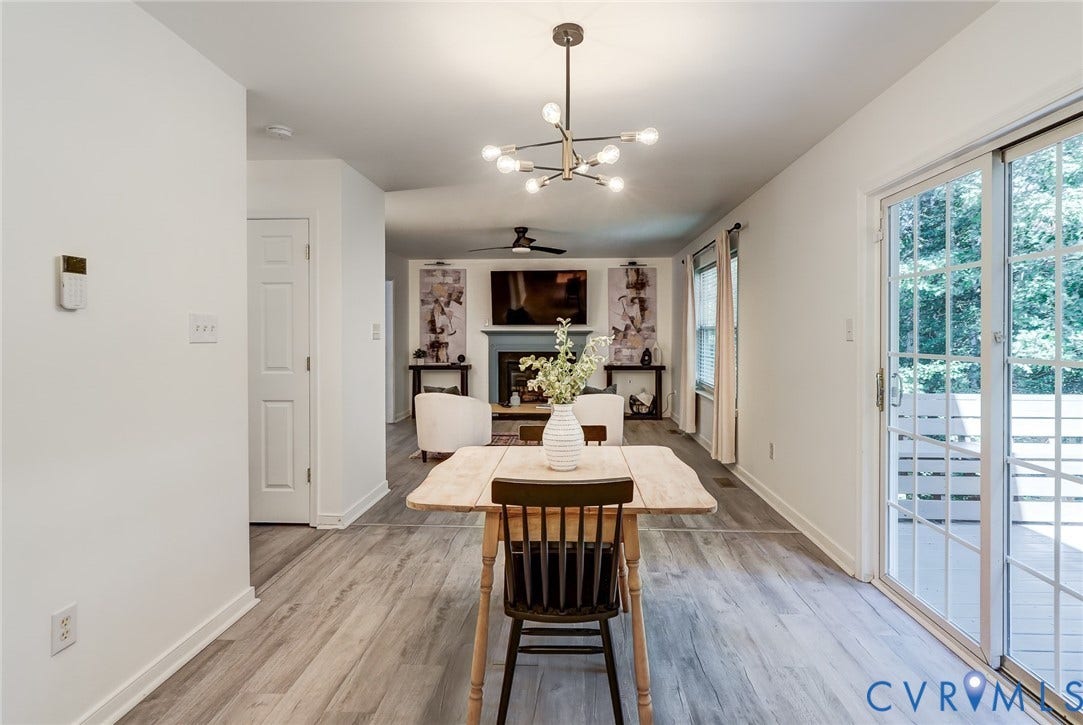 Wood-finish flooring throughout, modern chandelier, sliding glass door, and a built-in fireplace