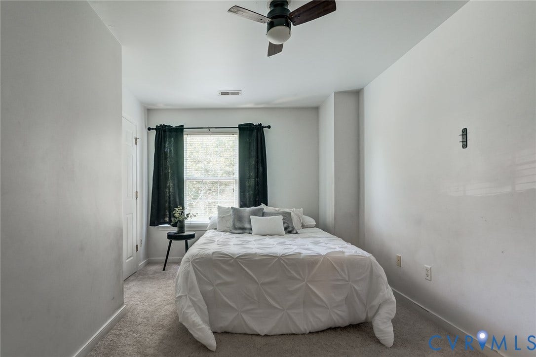 Recessed window with dark curtains, light-toned walls, and a ceiling fan