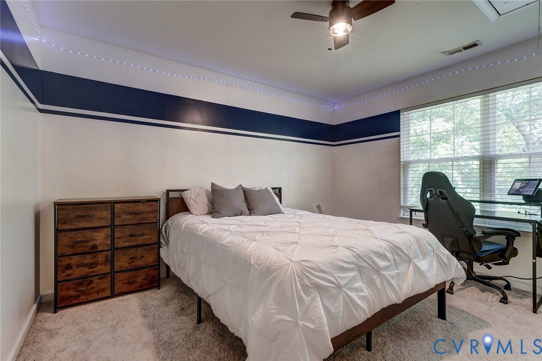 Recessed ceiling, wood-finish ceiling fan with integrated lighting, window with blinds, light-colored carpeting, baseboard trim