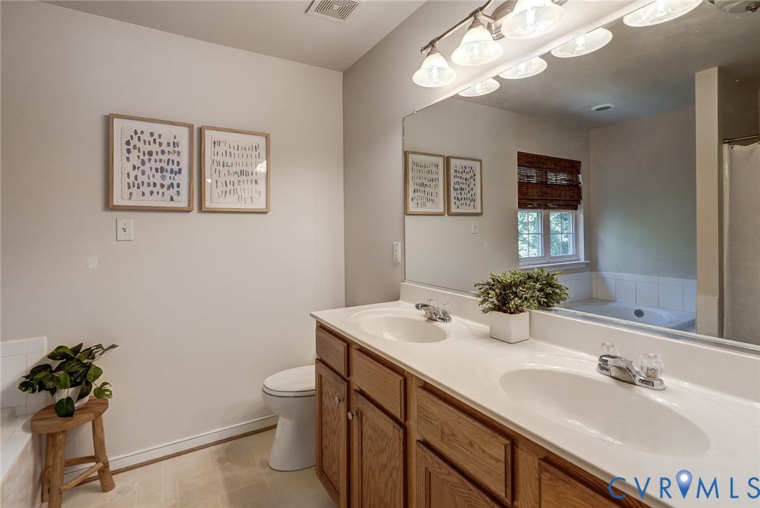 Dual vanity with light wood-finish cabinetry and integrated sinks