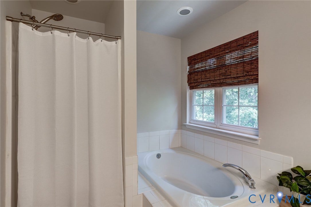 Built-in soaking tub with chrome fixtures, tiled surround, and recessed lighting
