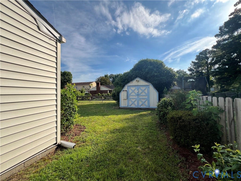 2112 Paramont Avenue, Collegue Park, Chesapeake, VA 23320 Expansive backyard featuring a manicured lawn, established landscaping, and a detached storage shed with double doors