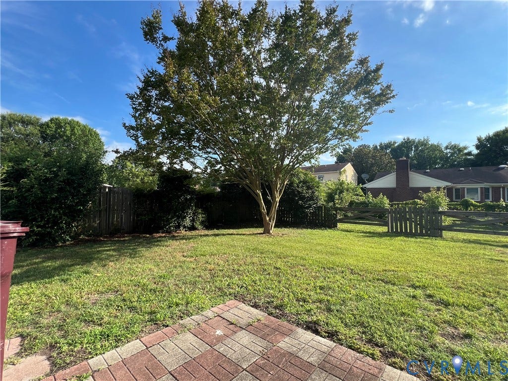 2112 Paramont Avenue, Collegue Park, Chesapeake, VA 23320 Expansive lawn with a mature central tree, surrounded by a wood fence and established shrubbery