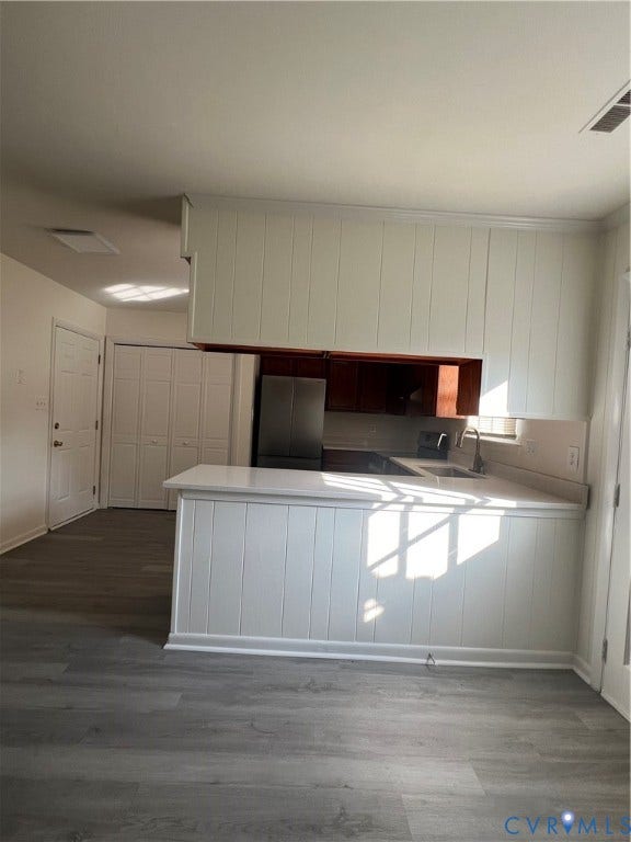 2112 Paramont Avenue, Collegue Park, Chesapeake, VA 23320 Kitchen featuring white paneled cabinetry, light-toned countertop, stainless steel refrigerator, and wood-finish flooring