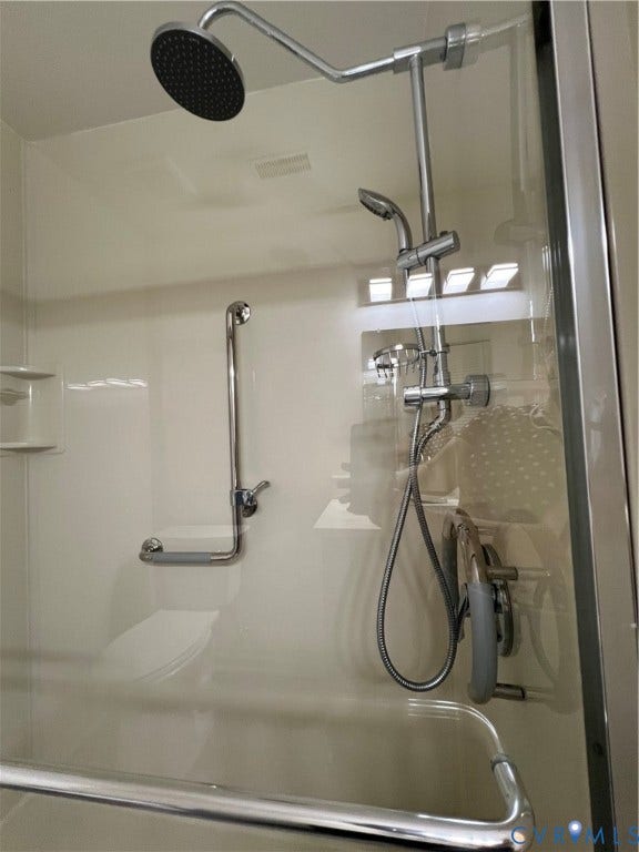 2112 Paramont Avenue, Collegue Park, Chesapeake, VA 23320 Shower stall with a fixed rainfall shower head, handheld shower fixture, and polished chrome grab bars