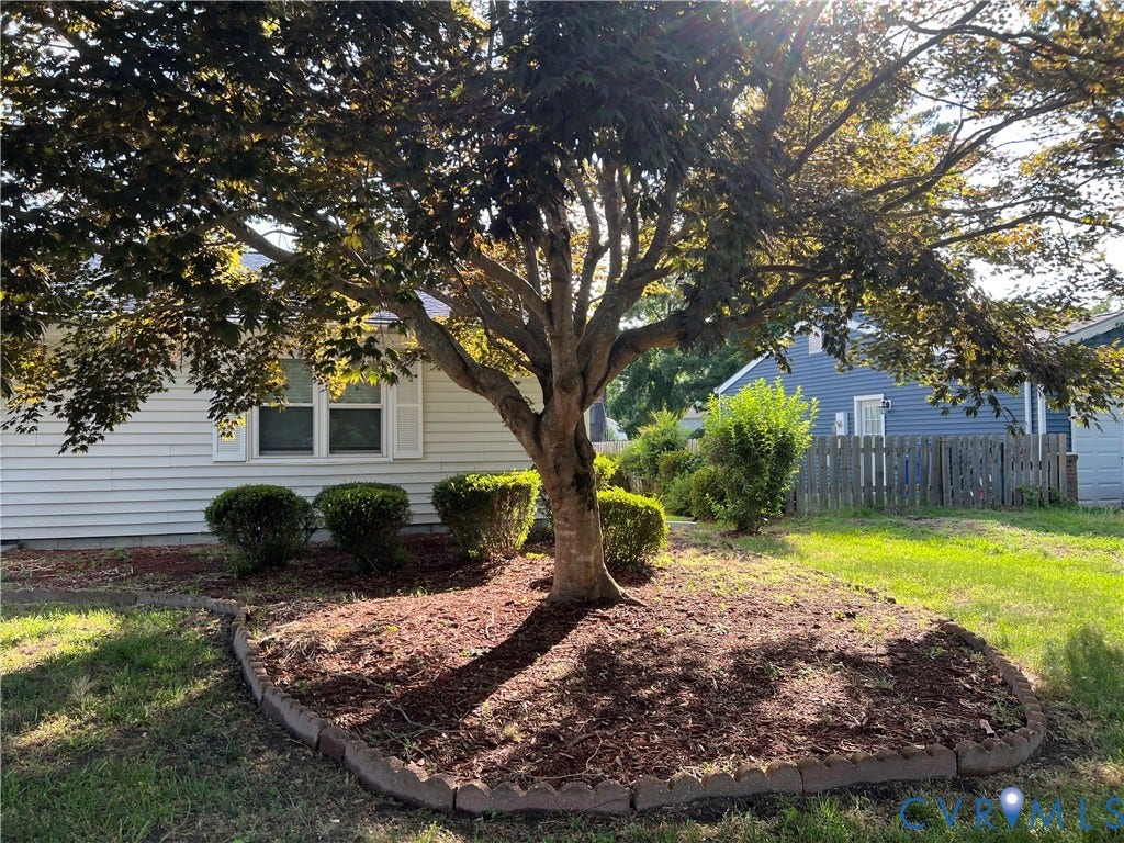 2112 Paramont Avenue, Collegue Park, Chesapeake, VA 23320 Mature tree with landscaping border, manicured shrubs, and white siding exterior