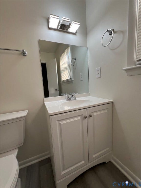 2112 Paramont Avenue, Collegue Park, Chesapeake, VA 23320 White vanity with integrated sink, chrome faucet, wall-mounted mirror, and overhead vanity lighting