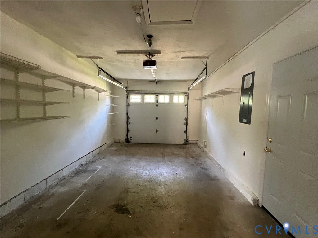 2112 Paramont Avenue, Collegue Park, Chesapeake, VA 23320 Attached garage featuring a white overhead door, built-in shelving, and a side access door