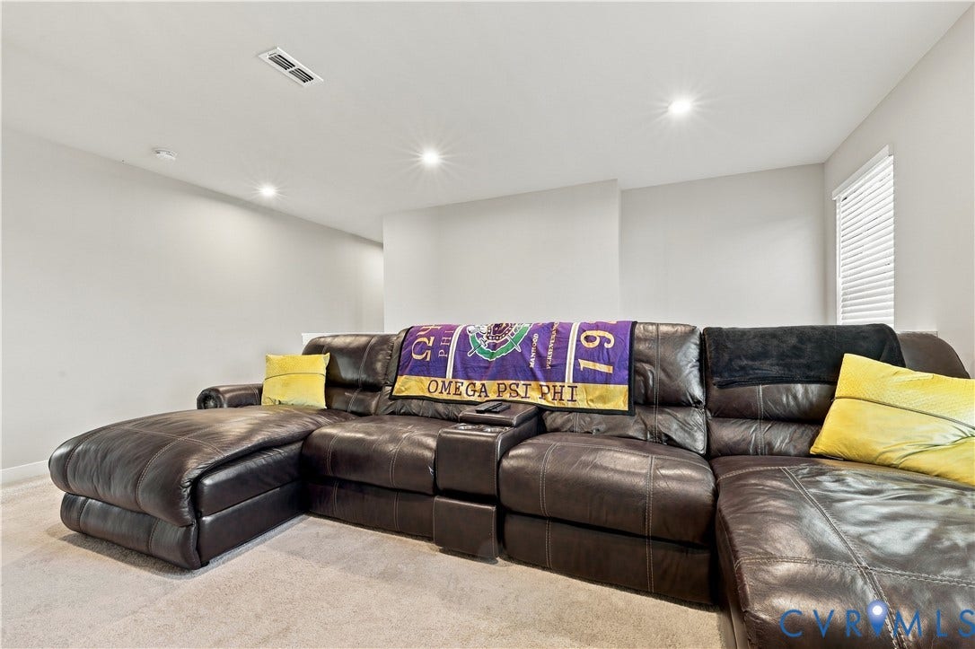 Recessed ceiling lighting, light gray wall paint, and light-colored carpeting