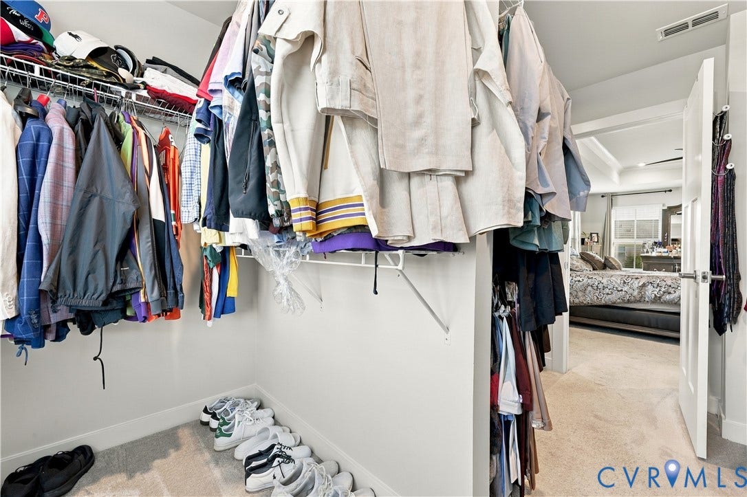 Walk-in closet featuring wire shelving and carpet flooring